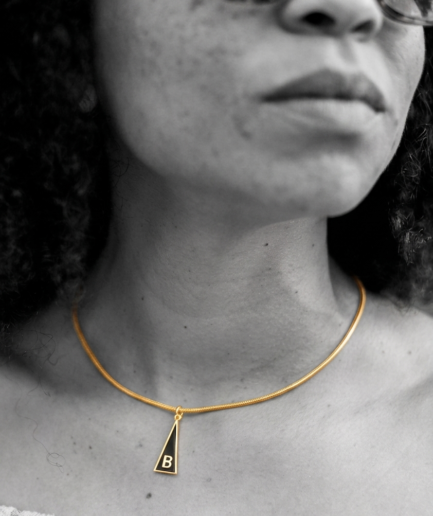 Medalla Inicial "B" de la Serie Triangular en latón con chapado en oro de 18K y esmalte negro.
