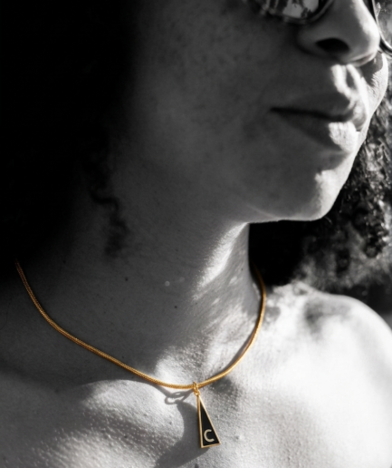 Medalla Inicial "C" de la Serie Triangular en latón con chapado en oro de 18K y esmalte negro.