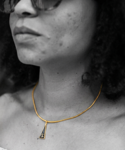 Medalla Inicial "S" de la Serie Triangular en latón con chapado en oro de 18K y esmalte negro.